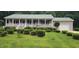 Charming ranch-style home featuring a metal roof, covered porch, and meticulously manicured front yard at 107 Oak Park Dr, Benson, NC 27504