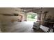 Open garage with storage shelving, work bench and an open door view to the front yard at 107 Oak Park Dr, Benson, NC 27504