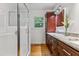 Bathroom with glass shower, cherry cabinets, marble countertops, and hardwood floors at 1304 N Duke St, Durham, NC 27701