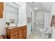 Bright bathroom with a white sink, wood vanity, and white bathtub with glass door at 1304 N Duke St, Durham, NC 27701