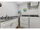 Functional laundry room with sink, granite counters, white cabinets, and washer/dryer at 1304 N Duke St, Durham, NC 27701