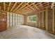 A large unfinished basement area with framing in place, a window and an exterior door at 1407 Arnette Ave, Durham, NC 27707
