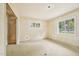Bright bedroom with a large window offering serene view, primed for renovation with bare walls and floors at 1407 Arnette Ave, Durham, NC 27707