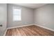 This bedroom features wood-look flooring, a window, and soft gray walls with vertical paneling at 1416 Betz St, Rocky Mount, NC 27803