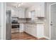 Renovated kitchen featuring stainless steel appliances, granite countertops, and white cabinetry at 1416 Betz St, Rocky Mount, NC 27803