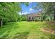 Expansive backyard with lush greenery, trees, and a house with deck at 1601 Balkan Rd, Fuquay Varina, NC 27526