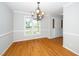Dining room with hardwood floors, bright windows, and a stylish chandelier at 1601 Balkan Rd, Fuquay Varina, NC 27526