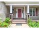 Inviting front porch with classic columns, decorative railings, and charming landscaping at 1601 Balkan Rd, Fuquay Varina, NC 27526