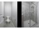 Bright bathroom featuring a toilet and glass-enclosed shower, with gray-toned tiling at 170 Kinsale Ct, Garner, NC 27529