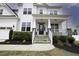 Inviting front porch with stone accents, manicured landscaping and a black front door at 170 Kinsale Ct, Garner, NC 27529
