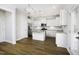 Modern white kitchen featuring stainless steel appliances, large island with granite countertop, and pendant lighting at 170 Kinsale Ct, Garner, NC 27529