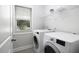 Well-lit laundry room with side-by-side washer and dryer, wire shelving and a window at 170 Kinsale Ct, Garner, NC 27529