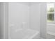 All-white shower and tub combination with integrated shelving and a window at 170 Kinsale Ct, Garner, NC 27529