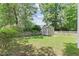 Large, grassy backyard with a storage shed and wooden privacy fence at 1801 Sagamore Ct, Raleigh, NC 27604