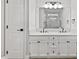 All-white bathroom with double sinks, modern lighting, and neutral accents at 1801 Sagamore Ct, Raleigh, NC 27604