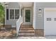 View of the welcoming front entrance with brick steps, gray siding, and modern lighting at 1801 Sagamore Ct, Raleigh, NC 27604