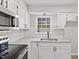 Bright kitchen with white cabinets, granite countertops, stainless steel appliances, and a window over the sink at 1801 Sagamore Ct, Raleigh, NC 27604