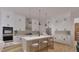 Spacious kitchen featuring white cabinets, stainless steel appliances, an island, and pendant lighting at 1804 Pershing Rd, Raleigh, NC 27608