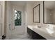 Modern bathroom featuring a double vanity, sleek mirrors, and natural light from a large window at 1806 Pershing Rd, Raleigh, NC 27608