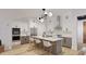 Bright, modern kitchen with an island, stainless steel appliances, and stylish light fixtures at 1806 Pershing Rd, Raleigh, NC 27608