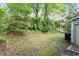 Lush backyard with mature trees and a utility shed for storage at 2 Capri Ter, Durham, NC 27703