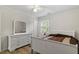 Bright bedroom features hardwood floors, bed with white frame and wooden dresser at 2 Capri Ter, Durham, NC 27703