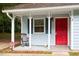 Inviting front porch with a rocking chair, bright red door, and white trim details at 2 Capri Ter, Durham, NC 27703
