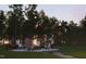 Cozy fire pit area with Adirondack chairs, surrounded by towering trees, creating a perfect outdoor retreat at 228 Alice Trace Place, Angier, NC 27501