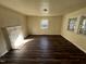 Spacious living room with dark wood floors, cream walls, white fireplace mantle and natural light from two windows at 2302 Chautauqua Ave, Durham, NC 27707
