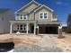 Two-story home under construction featuring board and batten siding, a brick facade, and a welcoming covered front porch at 245 Tidal Pool Way, Cary, NC 27519