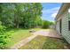 Spacious backyard with a brick patio, fire pit, and lush green landscaping at 248 Inkster Cv, Raleigh, NC 27603