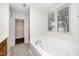 Bathroom showcasing a soaking tub with tile surround and a window at 248 Inkster Cv, Raleigh, NC 27603
