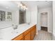 Bathroom featuring a double sink vanity with framed mirror, light fixture, and tile flooring at 248 Inkster Cv, Raleigh, NC 27603