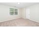 Bright bedroom with neutral carpet, fresh paint, a window, and a door at 248 Inkster Cv, Raleigh, NC 27603