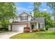 Landscaped front yard with a two-car garage and charming exterior details at 248 Inkster Cv, Raleigh, NC 27603