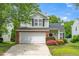 Two-story home with attached garage, trimmed with flowers, and nice curb appeal at 248 Inkster Cv, Raleigh, NC 27603