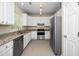 Modern kitchen features stainless steel appliances, granite counters, and bright, white cabinetry at 248 Inkster Cv, Raleigh, NC 27603