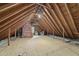 Unfinished attic space with exposed rafters, insulation, and a window, ready for customization at 2705 Vestry Way, Raleigh, NC 27613