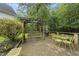 Back patio with brick pavers, wooden pergola swing set, and yellow metal table and chairs at 2705 Vestry Way, Raleigh, NC 27613