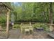 Back patio featuring yellow metal table and chairs, a wind chime, and natural, wooded views at 2705 Vestry Way, Raleigh, NC 27613