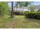 Back yard with a wooden deck, mature trees, and lush landscaping, offering shade and privacy at 2705 Vestry Way, Raleigh, NC 27613