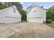 Two white garages with a concrete parking area nestled in a wooded backyard at 2705 Vestry Way, Raleigh, NC 27613