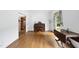 Bright living room featuring hardwood floors, piano, and doorway to another room with built-in shelves at 2705 Vestry Way, Raleigh, NC 27613