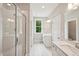 Bright bathroom featuring a glass shower, double sinks with vanity, window and white trim at 271 W Amber Oak Dr, Selma, NC 27576