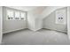 Lofted room with neutral walls, grey carpet, windows and white trim at 271 W Amber Oak Dr, Selma, NC 27576