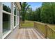 Wooden deck overlooking the backyard featuring lush trees and lawn at 271 W Amber Oak Dr, Selma, NC 27576