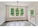 Bright dining area with wood floors, modern chandelier, and walk-out to deck at 271 W Amber Oak Dr, Selma, NC 27576