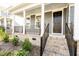 Inviting front porch with classic columns, brick accents, and black metal railings at 2918 Heirloom Way, Apex, NC 27502