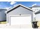 View of garage with white door and siding matching house, blue skies with minimal clouds at 2918 Heirloom Way, Apex, NC 27502