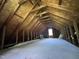 Large unfinished attic space with exposed beams and a window, perfect for storage or renovation at 3110 Fieldstone Ln, Mebane, NC 27302